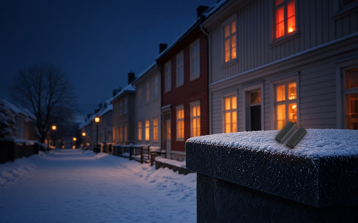 Todelt håndvarmer på en snødekket mur i en norsk gate en vinterkveld